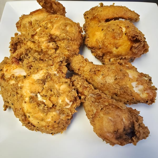 A white plate holds several pieces of crispy, golden-brown fried chicken from The Wardhurst Restaurant.