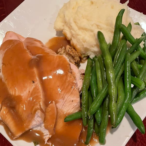 A plate of sliced turkey with gravy, mashed potatoes, and green beans from The Wardhurst Restaurant.